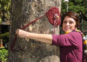 Contra o ódio, decoradora “planta” flores de crochê em árvores